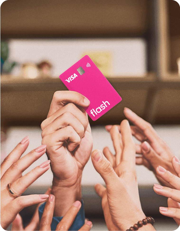 Mão ergue o cartão rosa de benefícios da Flash com a bandeira Visa.